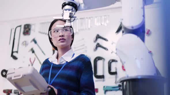 Asian female Engineers Maintenance Robot Arm at Lab. he are in a High Tech Research