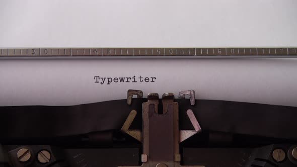Typing word Typewriter on retro typewriter. Close up.