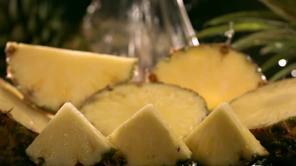 Slow Motion Shot of Pineapple and Water Splashing Through Pineapple Slices