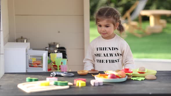 Happy Little Girl Playing on Toy Kitchen on Wheels