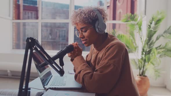 Side View African Woman Radio Host Working in Headphones Microphone While Talk