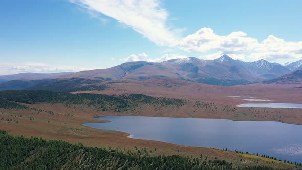 Aerial Panorama Over Blue Lake Background Of Picturesque Mountains