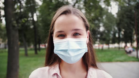 Pandemic is over. Taking off medical mask. Young woman deeply breathes smiling.