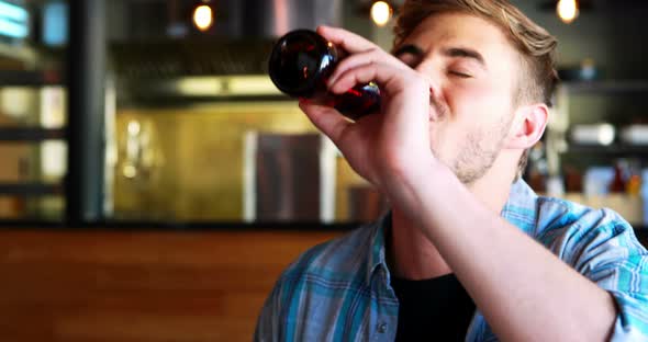 Man drinking beer while having burgers