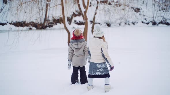 Curious children are walking together in a snowy background.