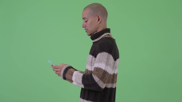 Profile View of Bald Multi Ethnic Man with Phone Being Taken Away