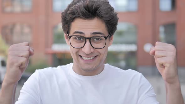 Outdoor Portrait of Young Man Celebrating Success