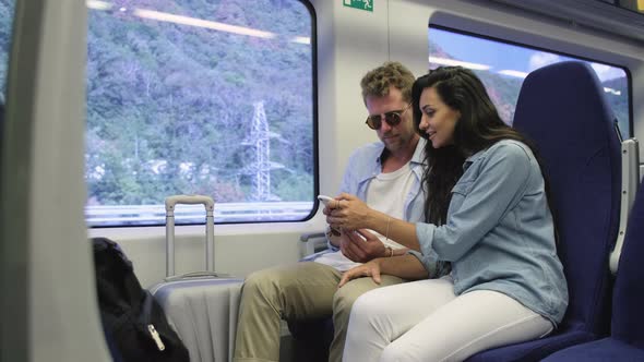 Happy Couple of Lovers Traveling in Train and Sitting Near Window