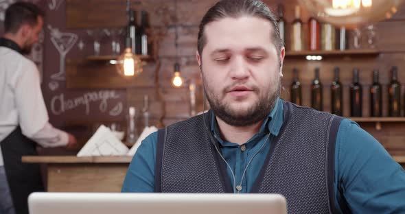 Attractive Man Having a Pleasant Conversation on His Laptop