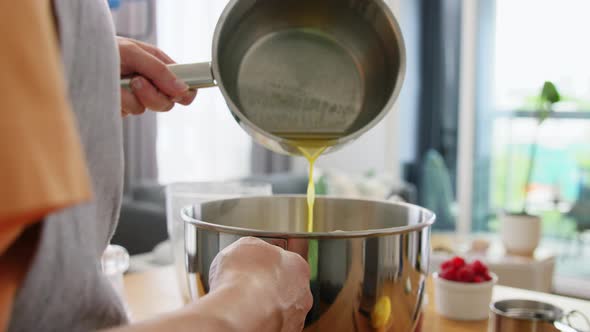 Woman Pouring Melted Butter to Bowl at Kitchen