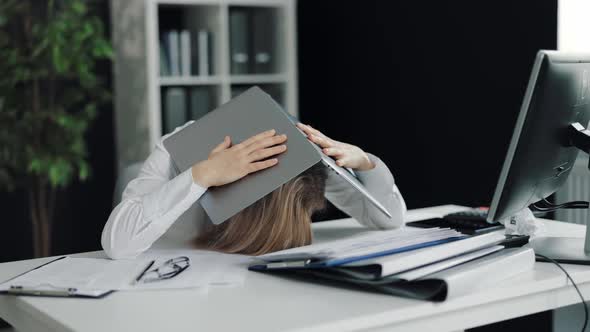 Depressed Woman with Laptop on Head