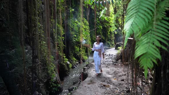 Divine Woman Walking in the Tropical Jungle Along the Brook Meditating Contemplation Burning