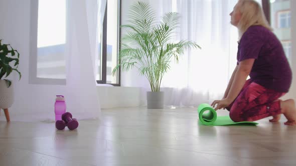 Fitness Training  Overweight Woman Spreads Out a Yoga Mat