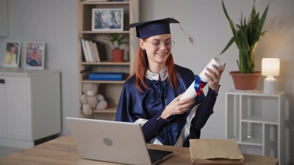 Distance Online Education Young Female Student University Graduate in Academic Clothes with Diploma