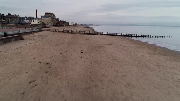 Flying over Portobello beach on a cloudy day. Rising up to give a view of the historic town centre.