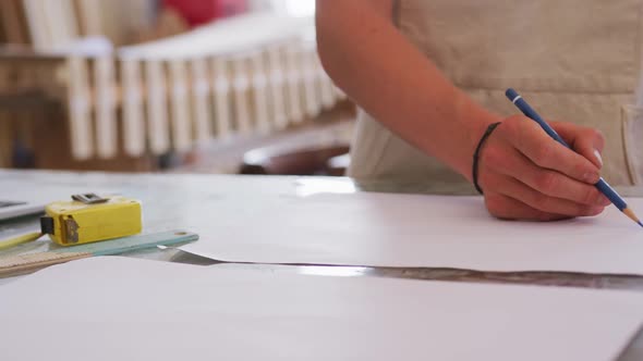 Caucasian male surfboard makers working in his studio