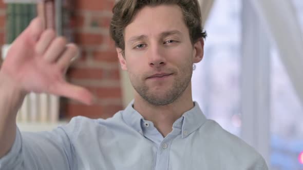 Portrait of Young Man Showing Thumbs Down