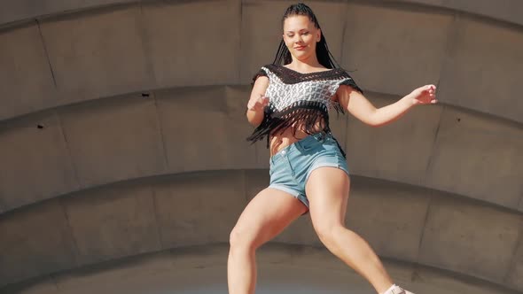 Dancing Female. happy mixed race woman dancing performance with long dreadlocks in shorts