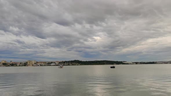 Cloud Timelapse Over Tagus River With Empty Boats Adrift In Seixal, South Bank Of Lisbon In Portugal