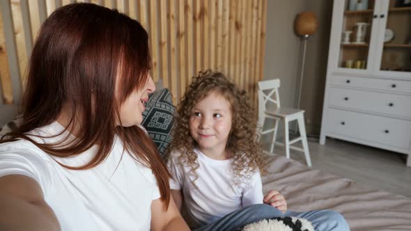 Brunette Mom and Girl with Long Hair Talk on Video Call