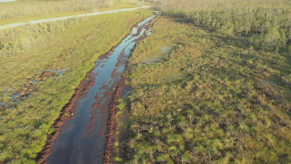 The Drone Flies Over a Broken Road in the Swamps of Siberia on Which Only Allterrain Vehicles Can