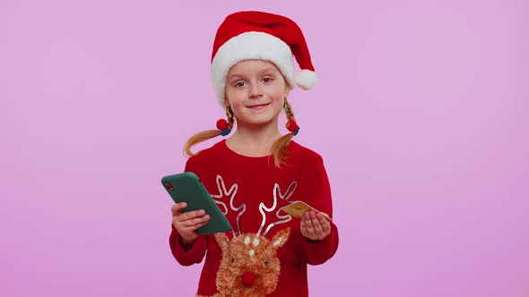 Girl in Christmas Sweater Using Credit Bank Card Smartphone While Transferring Money Shopping Online