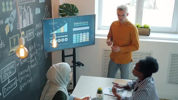 Ambitious Businessman Sharing Ideas with Colleagues Diverse Team Making Presentation in Office