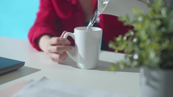 Office Worker Pour Water From a Kettle. Slowmotion