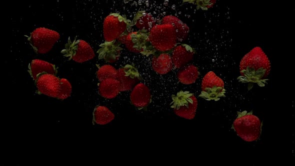 Slow Motion Strawberry Falling Into Transparent Water on Black Background