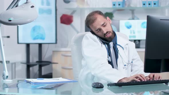 Doctor in His Modern Office Talking on the Phone