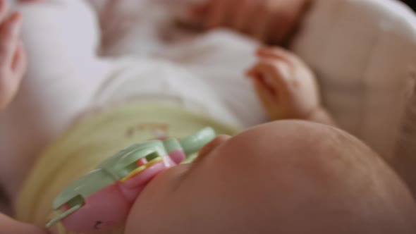 Newborn Baby Human Child Lies on His Back in a Stroller at Home