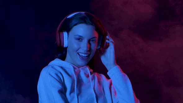 Portrait of Charming Young Woman Is Dancing and Enjoying Music in Big Red Headphones. Close Up. Slow