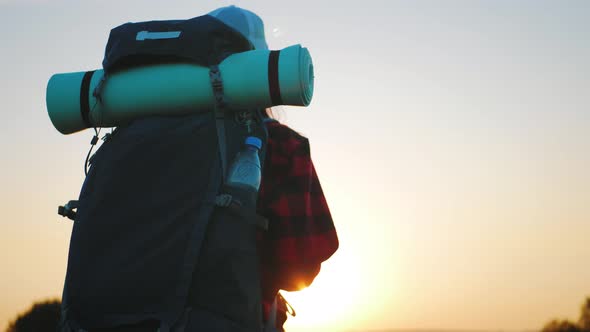 Woman Traveler with Backpack Hiking in Mountains. Silhouette Hiker Walking in the Mountains, Freedom