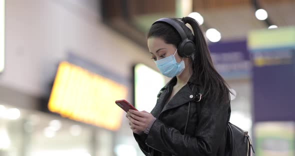 Chinese woman at train station in London wearing face mask to protect from sm