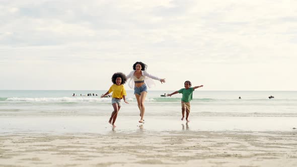 4K African mother walking and playing with little daughter and son on the beach on summer vacation.