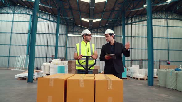 Factory Workers Deliver Boxes Package on a Pushing Trolley in the Warehouse