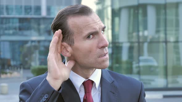 Secret Middle Aged Businessman Listening with Attention