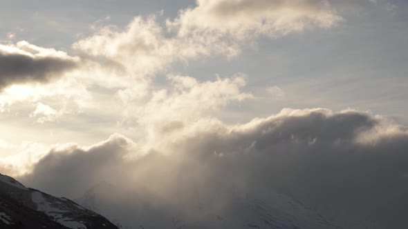 Timelapse Clouds Flow in the Mountains Flowing Over the Peaks in the Evening High Snow-capped