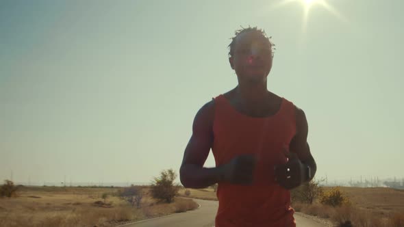 Black Male Athlete Runs Along the Road