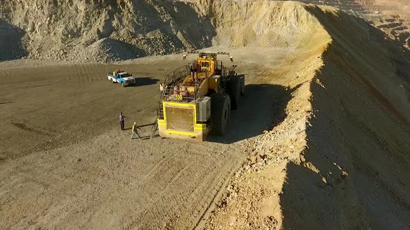 Rotating drone shot of large earther equipment at a rock quarry