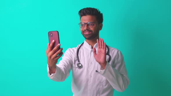 Latin Hispanic Doc Talking By Video Call with Patient in Blue Studio Background