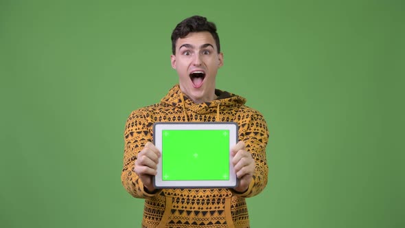 Young Handsome Man Showing Digital Tablet and Looking Surprised