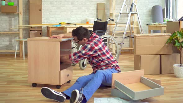 Disabled Man Is Engaged in the Repair of Tables