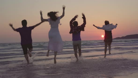 friends happy relax having fun playing on beach near sea when sunset in evening.