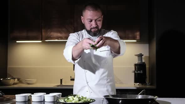 Cook man pours chopped ingredients into a wok pan to prepare a delicious dish.