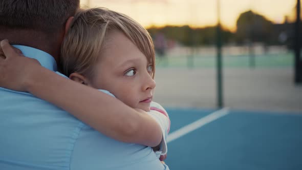 Happy father and son hugging on the court