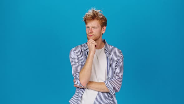 Pensive Redhead Man Touches Beard Listening to Companion