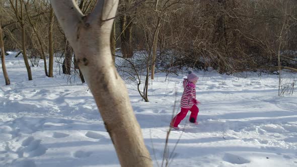 Joyful Little Child Girl Kid Running Towards on Snowy Road Through Winter Park Forest Outdoors