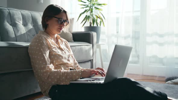 A Beautiful Middleaged Woman in Glasses Working on Her Laptop at Home