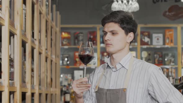 Winemaker Tasting Red Wine at His Shop